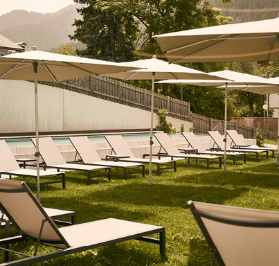 Gartenanlage Hotel Hirben mit Aussenpool und Liegestühle